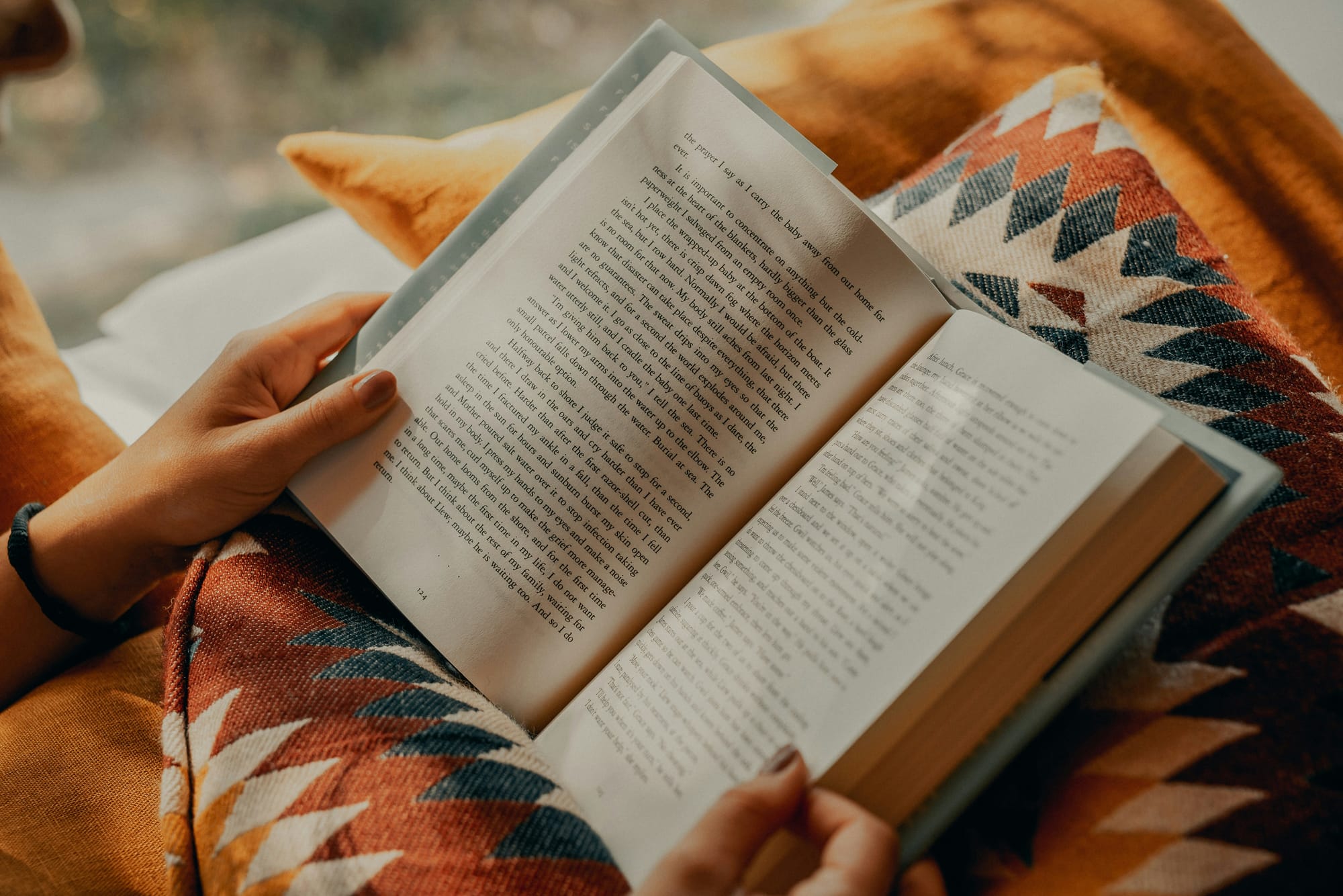 Woman reading a book on a pillow